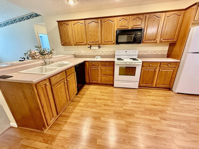 1012 Heathcliff Dr, Richmond, KY 40475 - kitchen with black appliances, light wood-style flooring, brown cabinetry, and light countertops