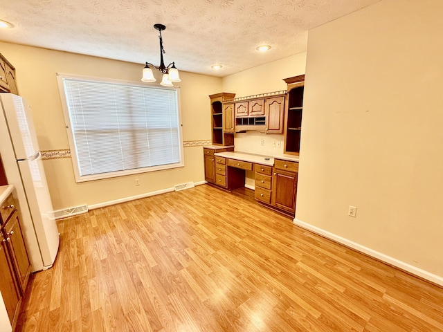 1012 Heathcliff Dr, Richmond, KY 40475 - kitchen with open shelves, freestanding refrigerator, light wood-style floors, light countertops, and a textured ceiling