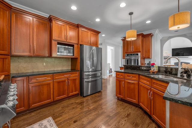 103 Windridge Dr, Nicholasville, KY 40356 - kitchen with appliances with stainless steel finishes, ornamental molding, brown cabinetry, pendant lighting, and dark wood-style floors