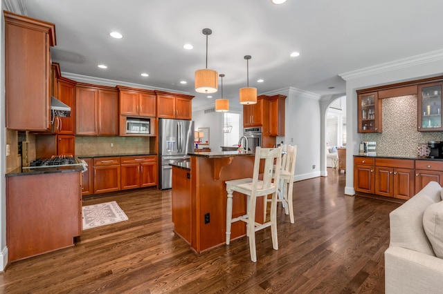103 Windridge Dr, Nicholasville, KY 40356 - kitchen featuring stainless steel appliances, crown molding, arched walkways, backsplash, and under cabinet range hood