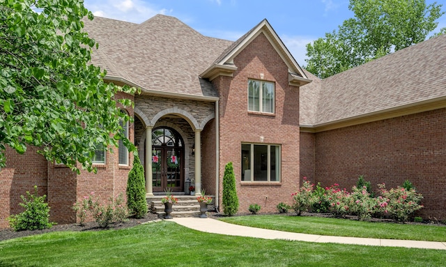 103 Windridge Dr, Nicholasville, KY 40356 - view of exterior entry featuring french doors, roof with shingles, a yard, and brick siding