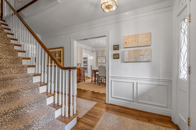 341 Kingsway Dr, Lexington, KY 40502 - foyer featuring crown molding, stairway, wood finished floors, healthy amount of natural light, and a decorative wall