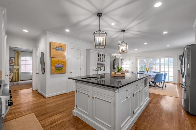 341 Kingsway Dr, Lexington, KY 40502 - kitchen with freestanding refrigerator, white cabinetry, a kitchen island with sink, dark stone countertops, and crown molding