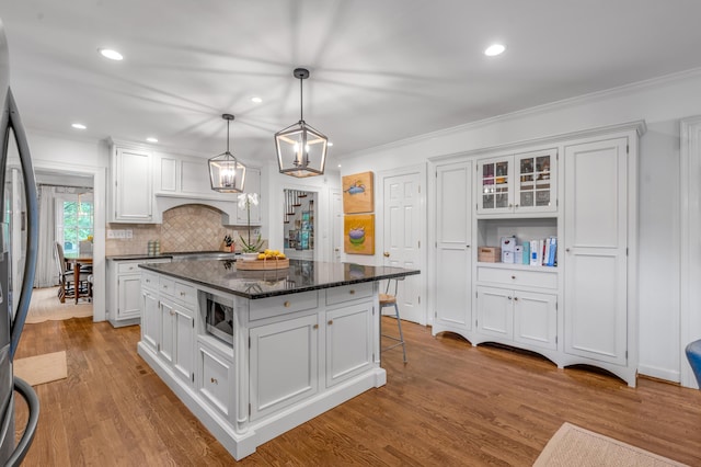 341 Kingsway Dr, Lexington, KY 40502 - kitchen with appliances with stainless steel finishes, white cabinets, ornamental molding, a kitchen island, and light wood finished floors