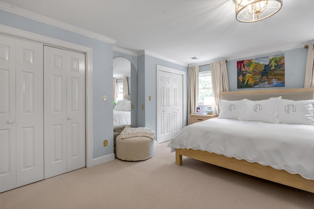 341 Kingsway Dr, Lexington, KY 40502 - carpeted bedroom with two closets, arched walkways, ornamental molding, and a chandelier