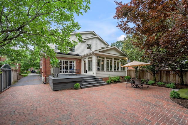 341 Kingsway Dr, Lexington, KY 40502 - back of house with a sunroom, a wooden deck, brick siding, outdoor dining space, and a patio area