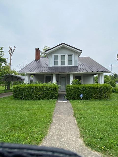 311 N Broadway St, Berea, KY 40403 - bungalow featuring a front lawn, a chimney, a metal roof, a porch, and a detached carport