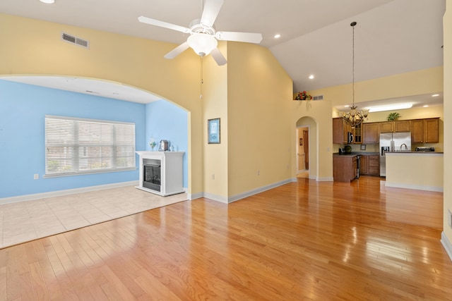 139 Delissa Dr, Georgetown, KY 40324 - unfurnished living room featuring high vaulted ceiling, a chandelier, light wood-style floors, ceiling fan, and a fireplace with raised hearth