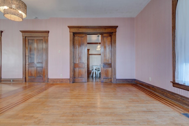 236 W High St, Mt Sterling, KY 40353 - unfurnished room with wood finished floors, wallpapered walls, and a chandelier