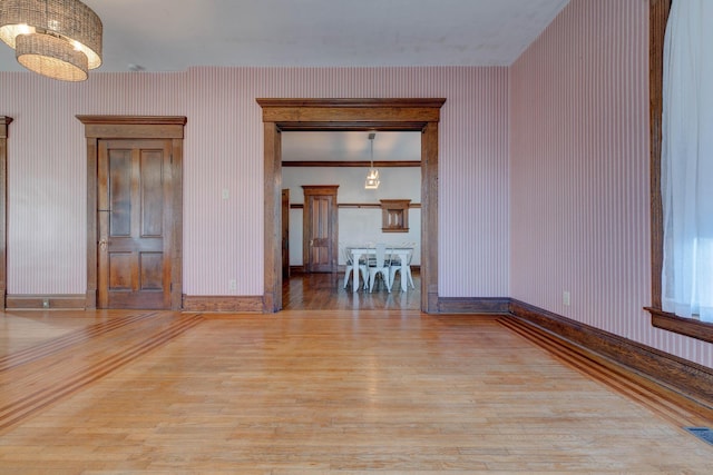 236 W High St, Mt Sterling, KY 40353 - empty room featuring wood finished floors, a chandelier, and wallpapered walls