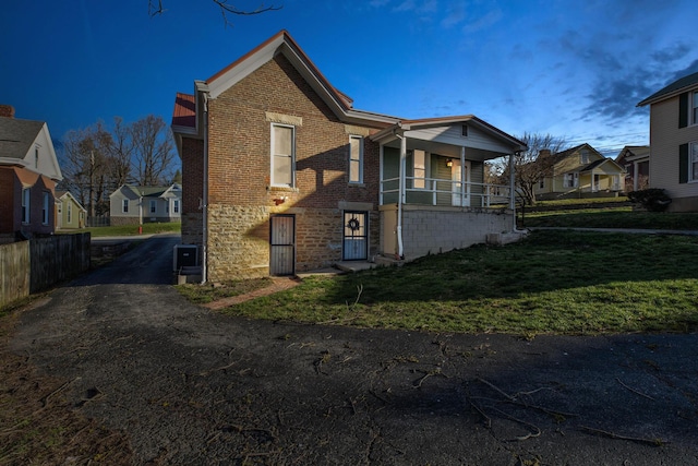 236 W High St, Mt Sterling, KY 40353 - view of side of home with a residential view, brick siding, a lawn, and a porch