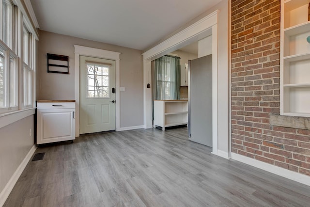 236 W High St, Mt Sterling, KY 40353 - foyer entrance with light wood-style floors and brick wall