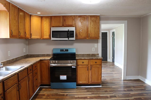 2721 E Ringgold, Somerset, KY 42503 - kitchen with appliances with stainless steel finishes, dark wood-style flooring, brown cabinetry, a textured ceiling, and ornamental molding