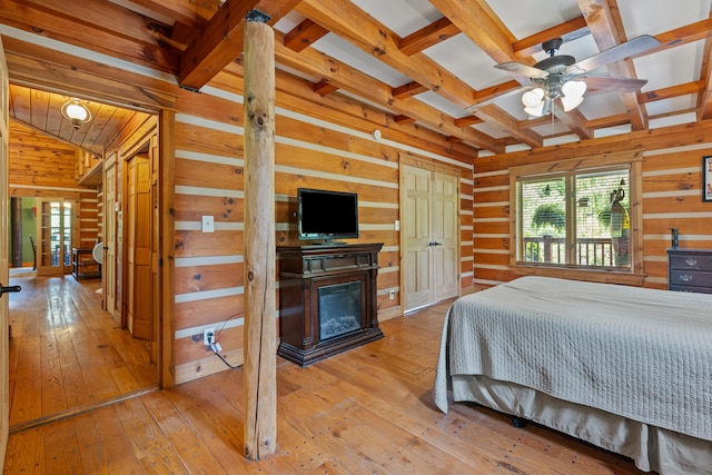1836 Red Lick Rd, Berea, KY 40403 - bedroom with wood walls, multiple windows, light wood-style flooring, a glass covered fireplace, and beamed ceiling