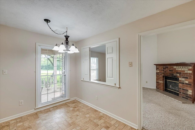396 Squires Cir, Lexington, KY 40515 - unfurnished dining area with a chandelier, a brick fireplace, and a textured ceiling