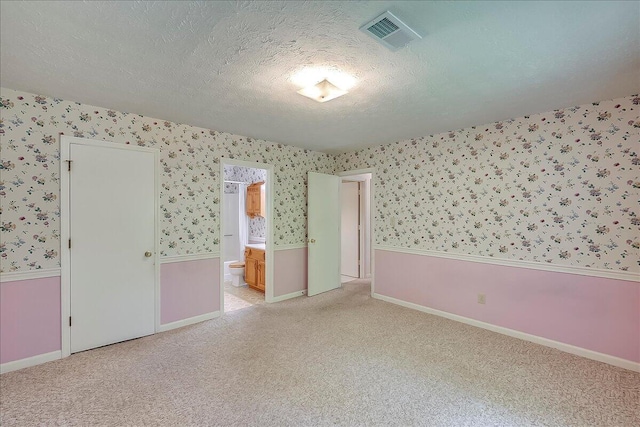 396 Squires Cir, Lexington, KY 40515 - unfurnished bedroom with wallpapered walls, a textured ceiling, light carpet, ensuite bathroom, and a wainscoted wall