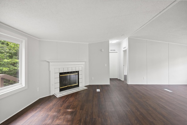 174 Sky Ln, Cynthiana, KY 41031 - unfurnished living room featuring wood finished floors, a tiled fireplace, a textured ceiling, and ornamental molding