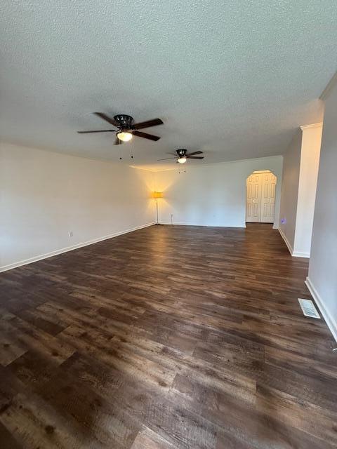 529 S 2nd St, Williamsburg, KY 40769 - empty room with ceiling fan, a textured ceiling, dark wood-style flooring, and arched walkways