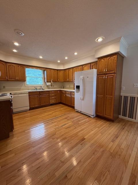 529 S 2nd St, Williamsburg, KY 40769 - kitchen featuring white appliances, brown cabinetry, crown molding, light wood finished floors, and light countertops