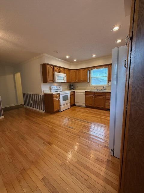 529 S 2nd St, Williamsburg, KY 40769 - kitchen featuring white appliances, light countertops, brown cabinetry, light wood-style floors, and ornamental molding