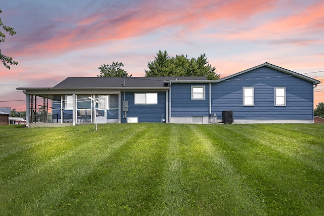 9209 W Hwy 80, Nancy, KY 42544 - back of house at dusk with a sunroom, a yard, and a metal roof