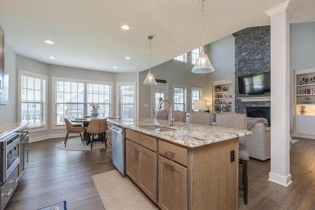 3536 Night Heron Way, Lexington, KY 40515 - kitchen featuring a breakfast bar, a fireplace, stainless steel dishwasher, dark wood-style flooring, and open floor plan