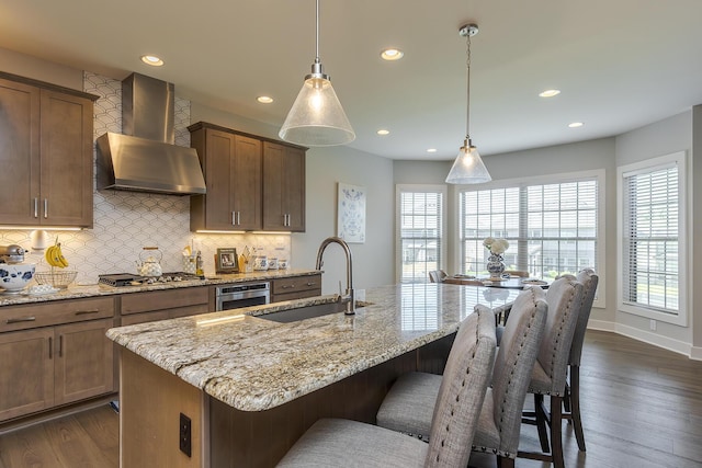 3536 Night Heron Way, Lexington, KY 40515 - kitchen with wall chimney range hood, decorative backsplash, light stone countertops, and recessed lighting