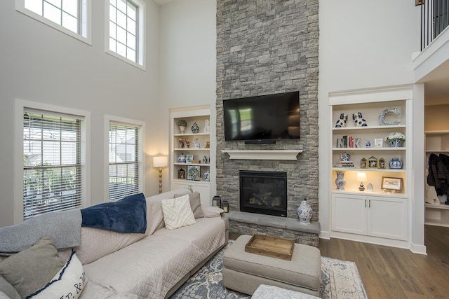 3536 Night Heron Way, Lexington, KY 40515 - living area featuring dark wood-style floors, a stone fireplace, healthy amount of natural light, a towering ceiling, and built in shelves
