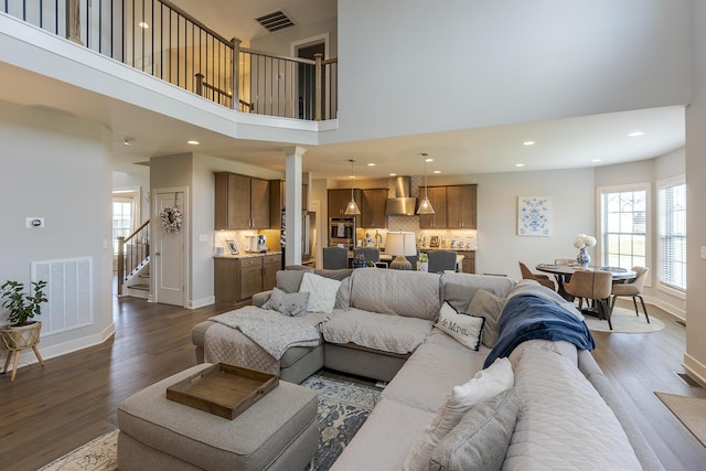 3536 Night Heron Way, Lexington, KY 40515 - living room featuring dark wood-style flooring, stairs, recessed lighting, a high ceiling, and ornate columns