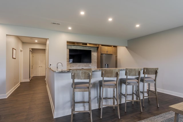 3536 Night Heron Way, Lexington, KY 40515 - kitchen with stainless steel fridge with ice dispenser, light stone counters, recessed lighting, a breakfast bar area, and dark wood-type flooring