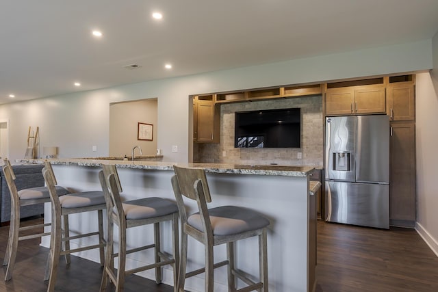 3536 Night Heron Way, Lexington, KY 40515 - kitchen featuring stainless steel fridge with ice dispenser, dark wood finished floors, recessed lighting, light stone counters, and a kitchen breakfast bar