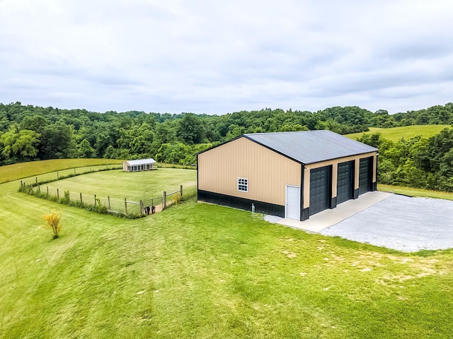 1011 Brown Store Rd, Lawrenceburg, KY 40342 - view of home's exterior featuring a garage, an outdoor structure, an outbuilding, a metal roof, and a view of trees
