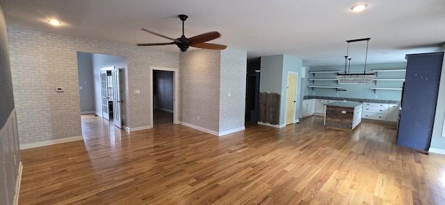4020 Greentree Rd, Versailles, KY 40383 - unfurnished living room with brick wall, ceiling fan, and wood finished floors