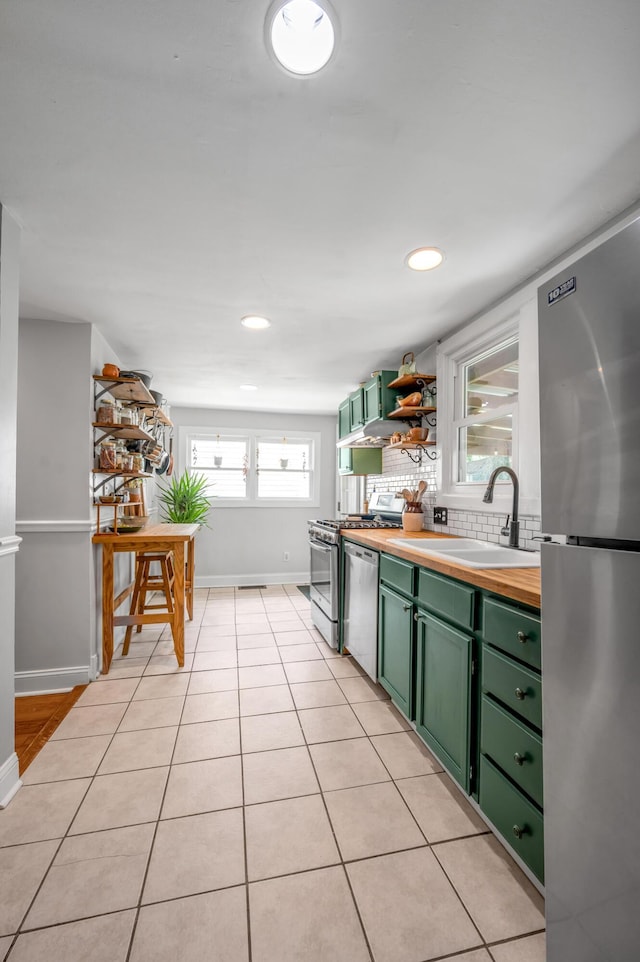 334 Oldham Ave, Lexington, KY 40502 - kitchen featuring green cabinetry, appliances with stainless steel finishes, backsplash, light tile patterned floors, and butcher block counters