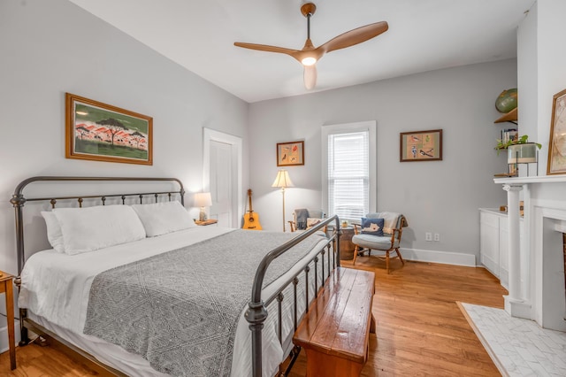 334 Oldham Ave, Lexington, KY 40502 - bedroom featuring light wood-style flooring, ceiling fan, and a fireplace with flush hearth