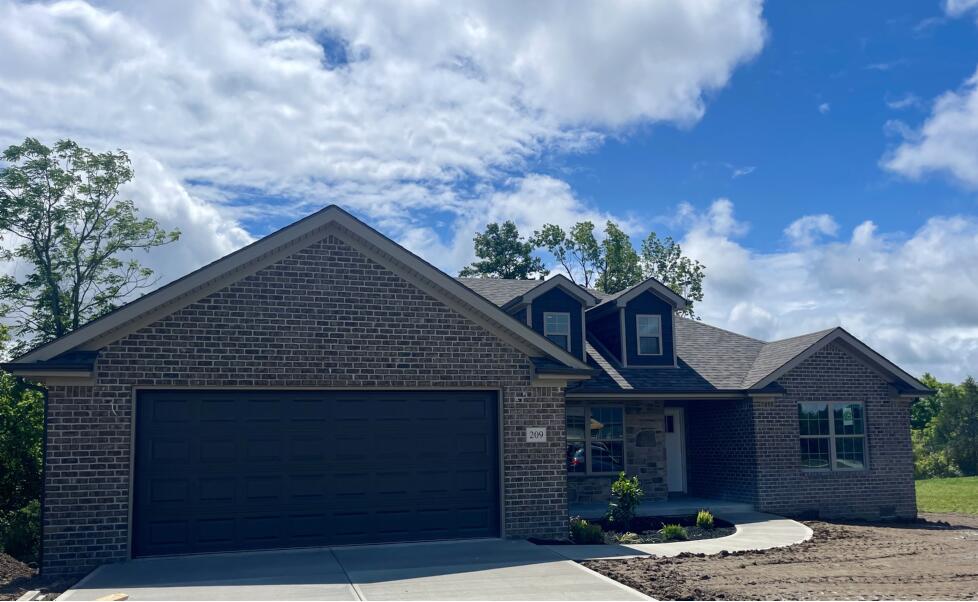 209 Patriot Trl, Berea, KY 40403 - view of front of house with brick siding, a garage, driveway, and covered porch