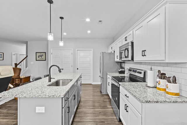 111 Kara Bryn Cv, Georgetown, KY 40324 - kitchen with stainless steel appliances, a kitchen island with sink, recessed lighting, white cabinetry, and decorative backsplash
