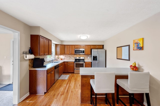 441 Cromwell Way, Lexington, KY 40503 - kitchen featuring stainless steel appliances, a peninsula, light countertops, tasteful backsplash, and a kitchen breakfast bar
