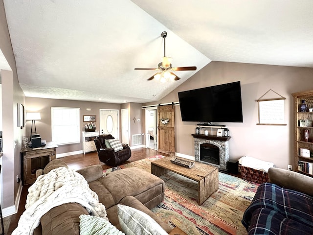 51 Stony Brook Dr, Corbin, KY 40701 - living room featuring wood finished floors, ceiling fan, vaulted ceiling, a barn door, and a fireplace