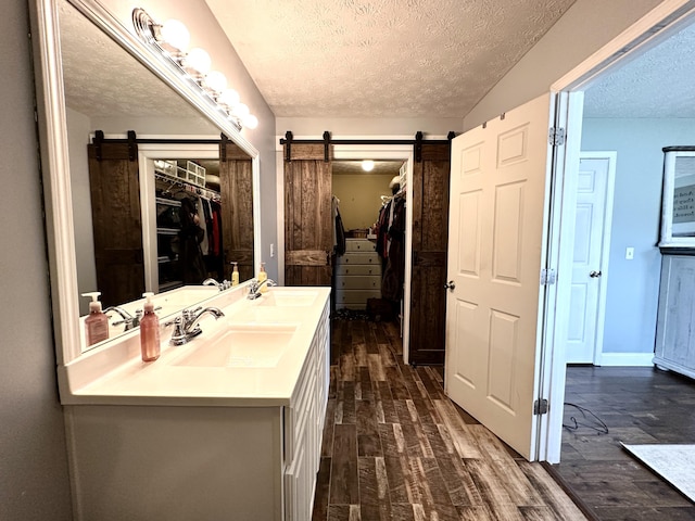 51 Stony Brook Dr, Corbin, KY 40701 - full bathroom featuring a textured ceiling, a spacious closet, wood finished floors, and double vanity