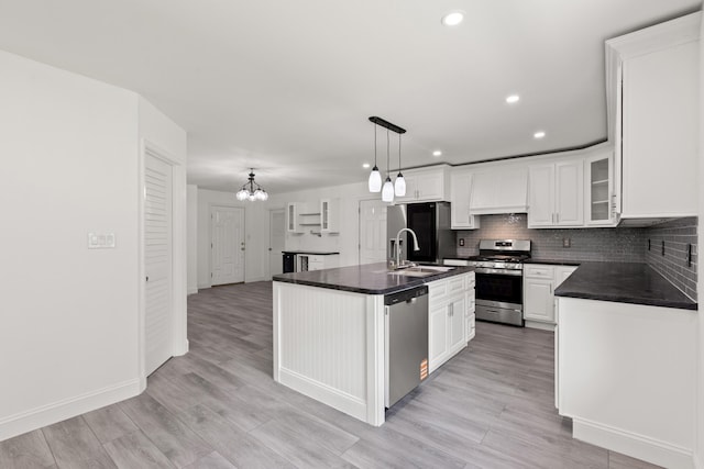 117 S Cumberland St, Berea, KY 40403 - kitchen featuring stainless steel appliances, dark countertops, a chandelier, white cabinetry, and decorative backsplash