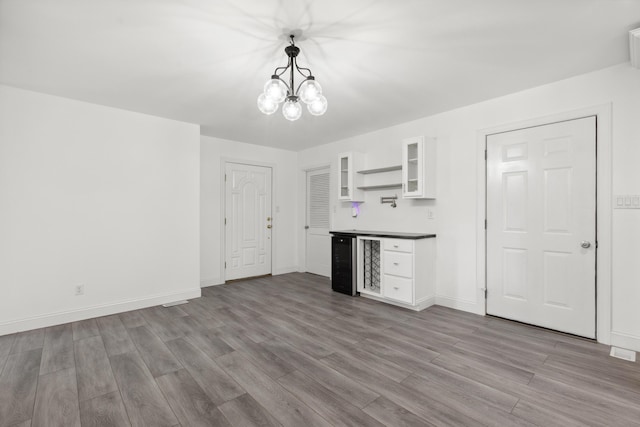 117 S Cumberland St, Berea, KY 40403 - kitchen with beverage cooler, white cabinetry, wood finished floors, and a chandelier