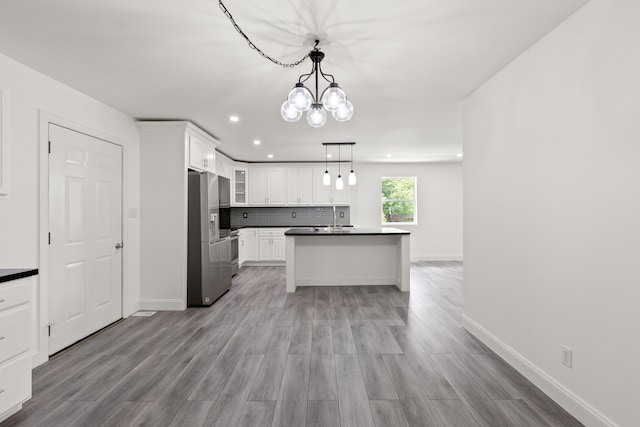 117 S Cumberland St, Berea, KY 40403 - kitchen with stainless steel fridge, dark countertops, a chandelier, white cabinets, and decorative backsplash