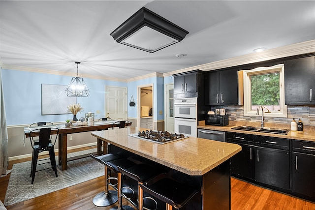 1211 Forest Circle Dr, Corbin, KY 40701 - kitchen featuring dark cabinets, stainless steel appliances, a center island, light wood finished floors, and ornamental molding