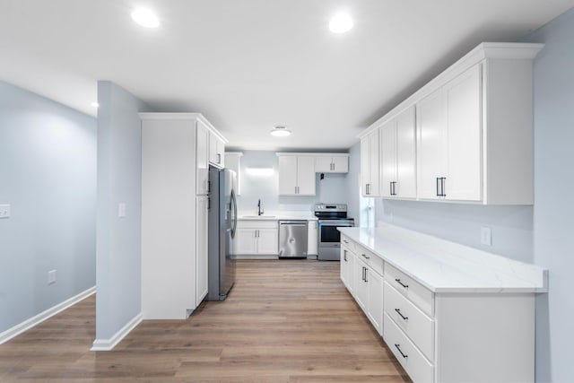 423 Perryville St, Harrodsburg, KY 40330 - kitchen featuring appliances with stainless steel finishes, recessed lighting, white cabinetry, light wood-type flooring, and light stone countertops