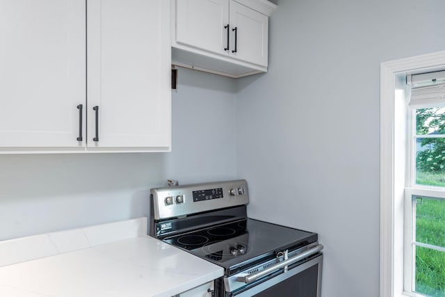 423 Perryville St, Harrodsburg, KY 40330 - kitchen featuring stainless steel range with electric stovetop, white cabinets, and light stone counters