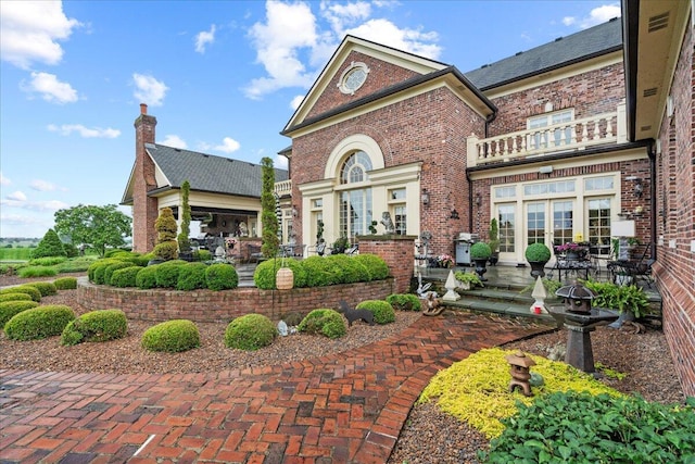 5045 Van Meter Rd, Winchester, KY 40391 - view of front of home with a balcony, a patio, brick siding, and a chimney