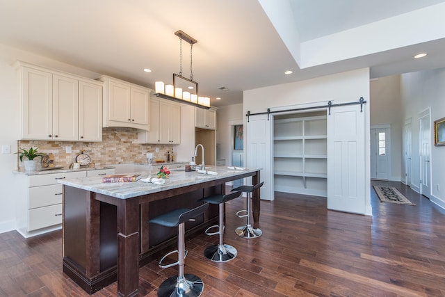 4185 Buttermilk Rd, Lexington, KY 40509 - kitchen featuring a barn door, recessed lighting, light stone countertops, dark wood-style floors, and tasteful backsplash