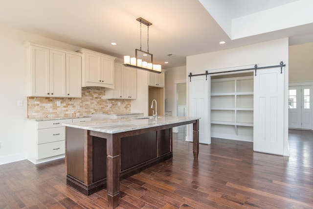 4185 Buttermilk Rd, Lexington, KY 40509 - kitchen featuring a barn door, dark wood-style flooring, recessed lighting, tasteful backsplash, and an island with sink