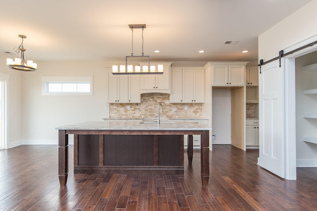 4185 Buttermilk Rd, Lexington, KY 40509 - kitchen featuring a barn door, decorative backsplash, a breakfast bar, dark wood-style floors, and an island with sink
